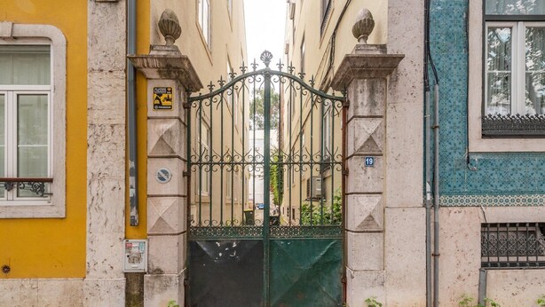 Eine enge Straße mit einem verschlossenen Eingang, Kopfsteinpflaster und Gebäuden mit unterschiedlichen Architekturstilen.