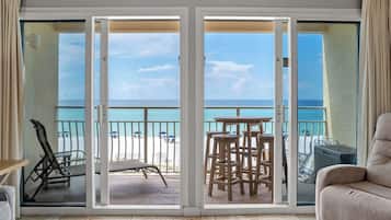 Ein Balkon mit Blick auf den Strand, einer Liege und einer Bar.