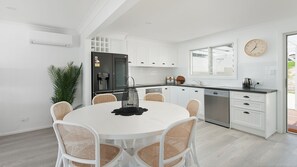 Enjoy meals in this kitchen with a round dining table and stainless steel appliances.