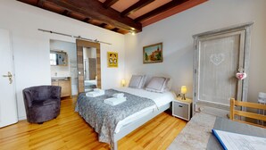 A bedroom with a bed, bedside tables, a chair, a wardrobe, and a mirror.