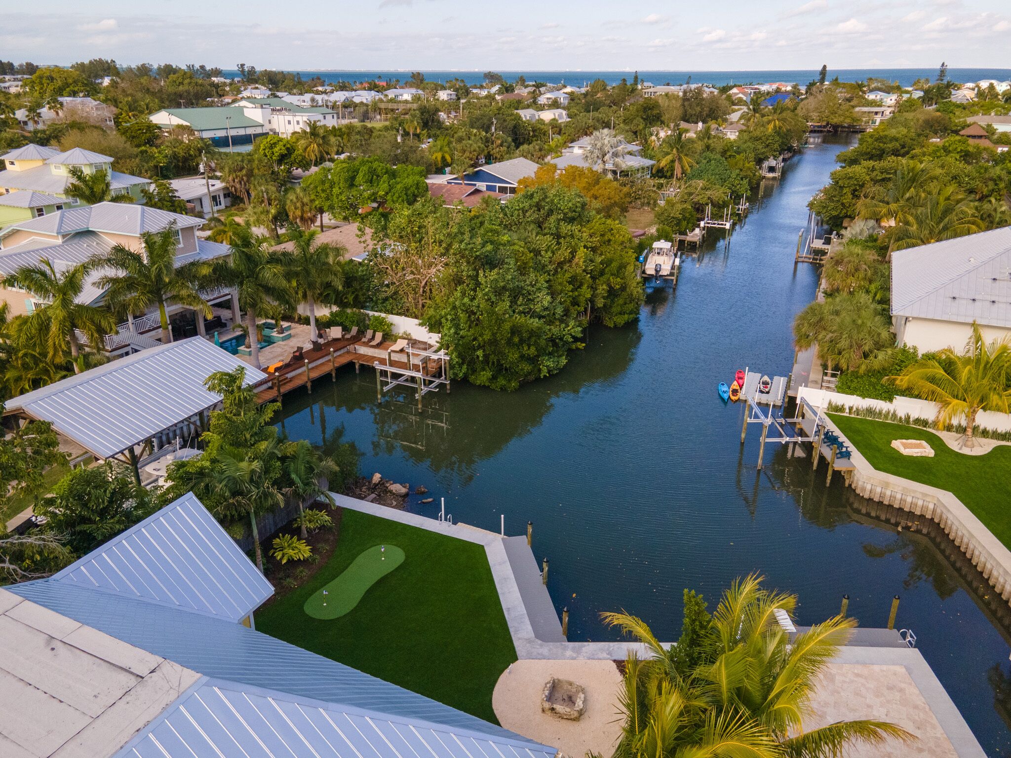 A residential area with a canal, houses, and a dock.