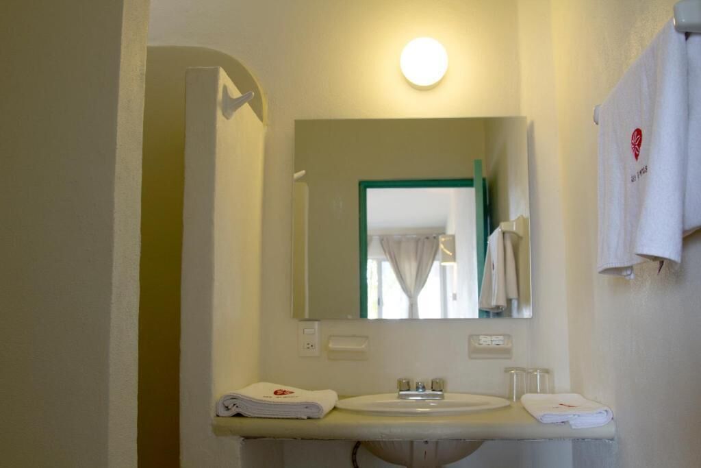 Un bagno con lavandino, specchio e portasciugamani.