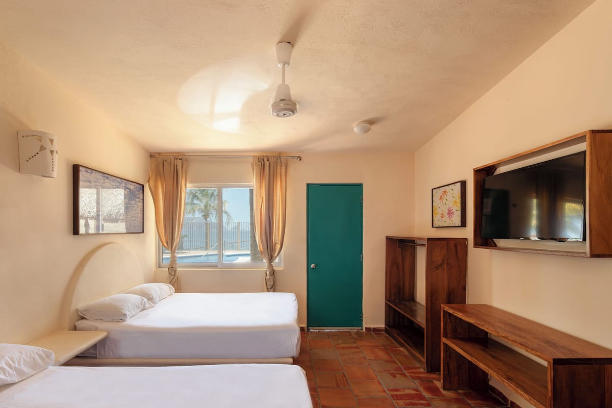 Habitación Cuádruple 2, 2 Camas Dobles | Brankas, setrika/meja setrika, Wi-Fi gratis, dan seprai linen