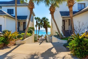 Enjoy breathtaking ocean views from this modern property, surrounded by palm trees and a central pathway.