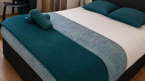 Une chambre à coucher avec un lit, une chaise, une armoire, un tableau et une fenêtre avec des rideaux.