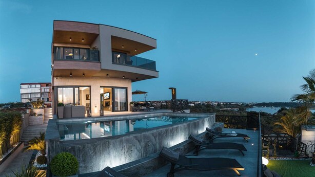 A modern multi-story house with a swimming pool, outdoor seating, and a view of the sea. - Villa La Vie with Pool (Medulin)