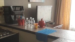 A kitchen with a marble countertop, a painting of a cityscape, a red apple, and a window with curtains. - independent apartment near airport photos prints visa american embassy (Bogotá)