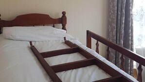 A bed with a wooden frame and white bedding. - Apsley House Flat 1 - 4 Berth (Great Yarmouth)