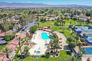 A resort with a large swimming pool, tennis courts, and a golf course.