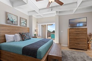 Relax in this serene bedroom with a large bed, wooden headboard, and flat-screen TV.