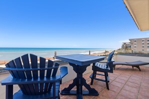 Enjoy ocean views from this outdoor patio with a table and chairs.