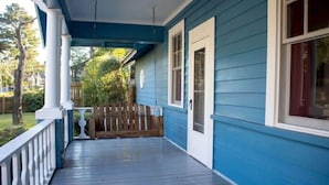 A blue house with a covered porch, white railings, and a wooden fence. - Fenced-In Yard & Nice Patio! Capital State Heights (Montgomery)