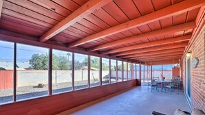 A covered patio area with a long bench, a table with chairs, and a view of the outdoors. - Southwest Sanctuary! Tucson Home w/ Patio & Yard (Tucson)