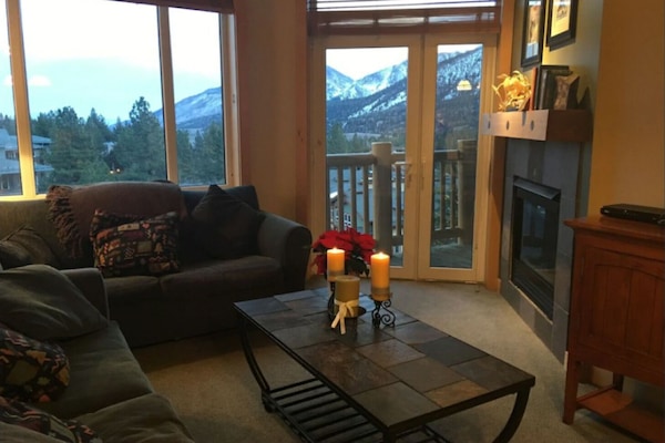 Living area with fireplace, views, and access to outdoor balcony.