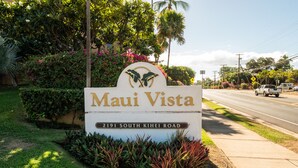 A sign for 'Maui Vista' at 2191 South Kihei Road, featuring a logo with dolphins and lush greenery.