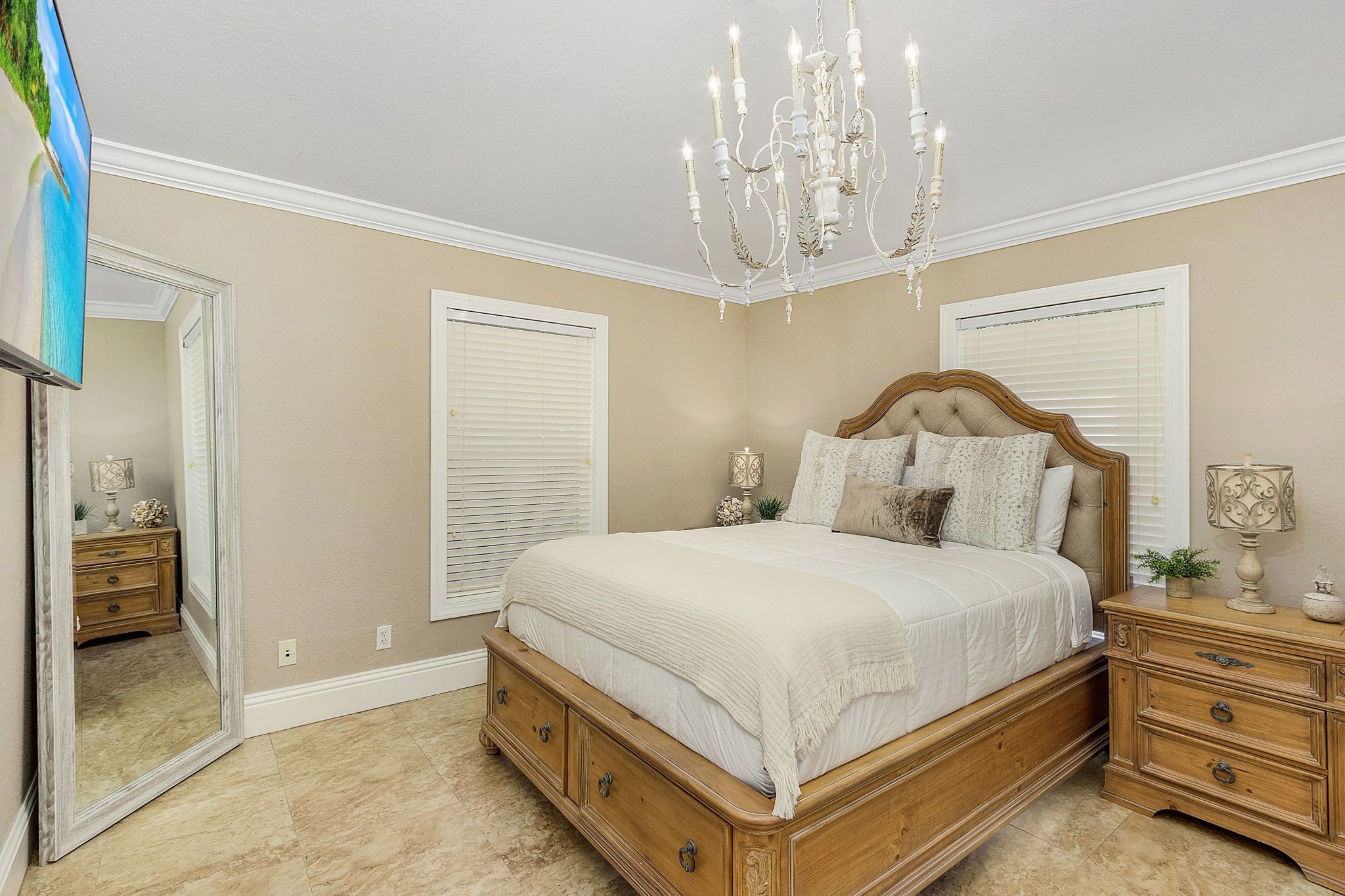 Un dormitorio con una cama de madera, un candelabro, una mesita de noche y un espejo.
