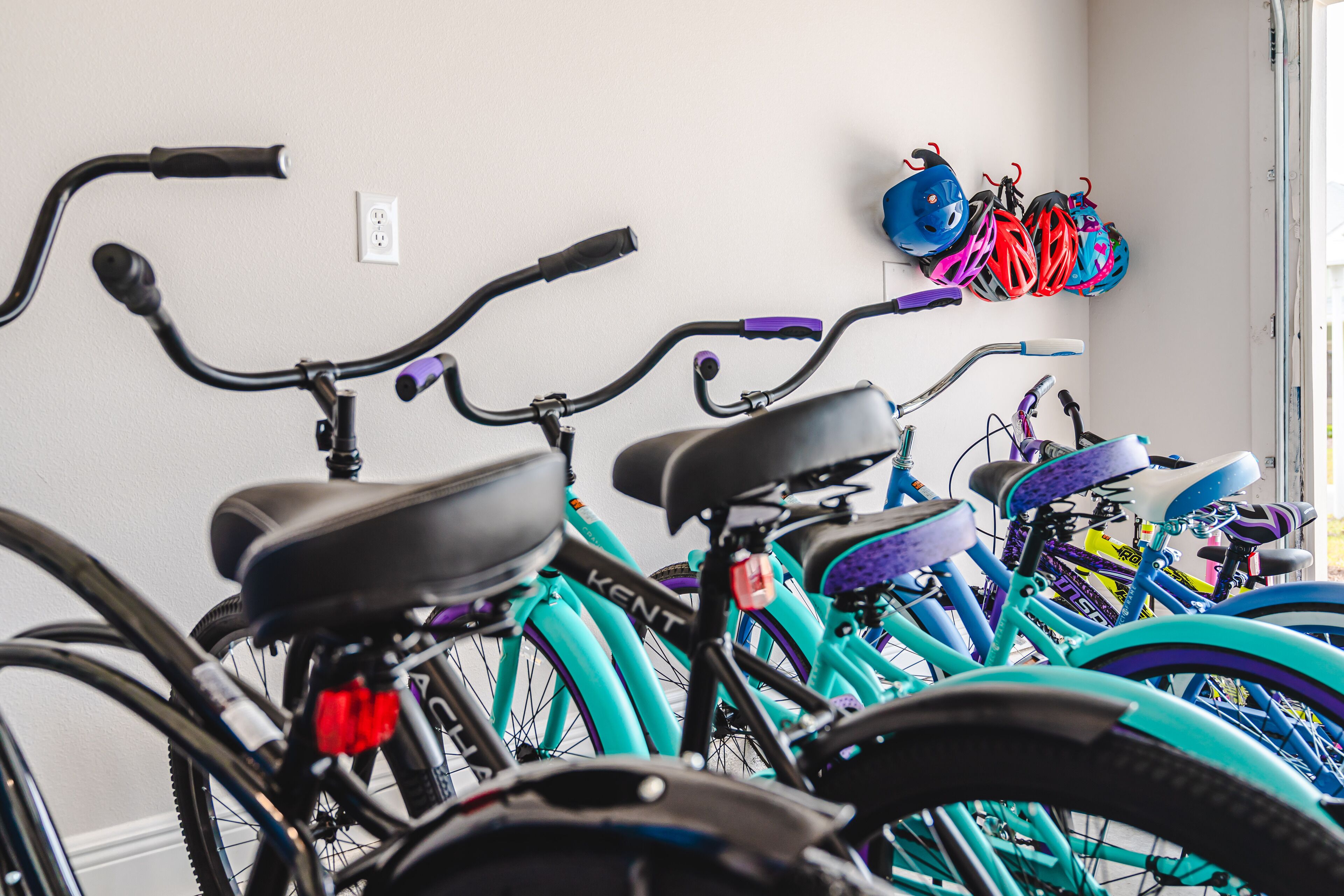 Varias bicicletas con un soporte de pared y cascos.