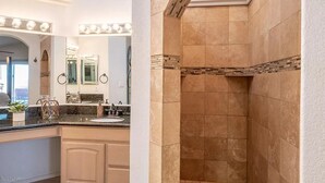 Une salle de bain équipée d’un meuble-lavabo, d’un miroir et d’un espace douche.