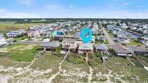 An aerial view of a coastal residential area with houses, a beach, and a marina. - "After Dune Delight" oceanfront, 7 bedroom 3 bathrooms (Holden Beach)