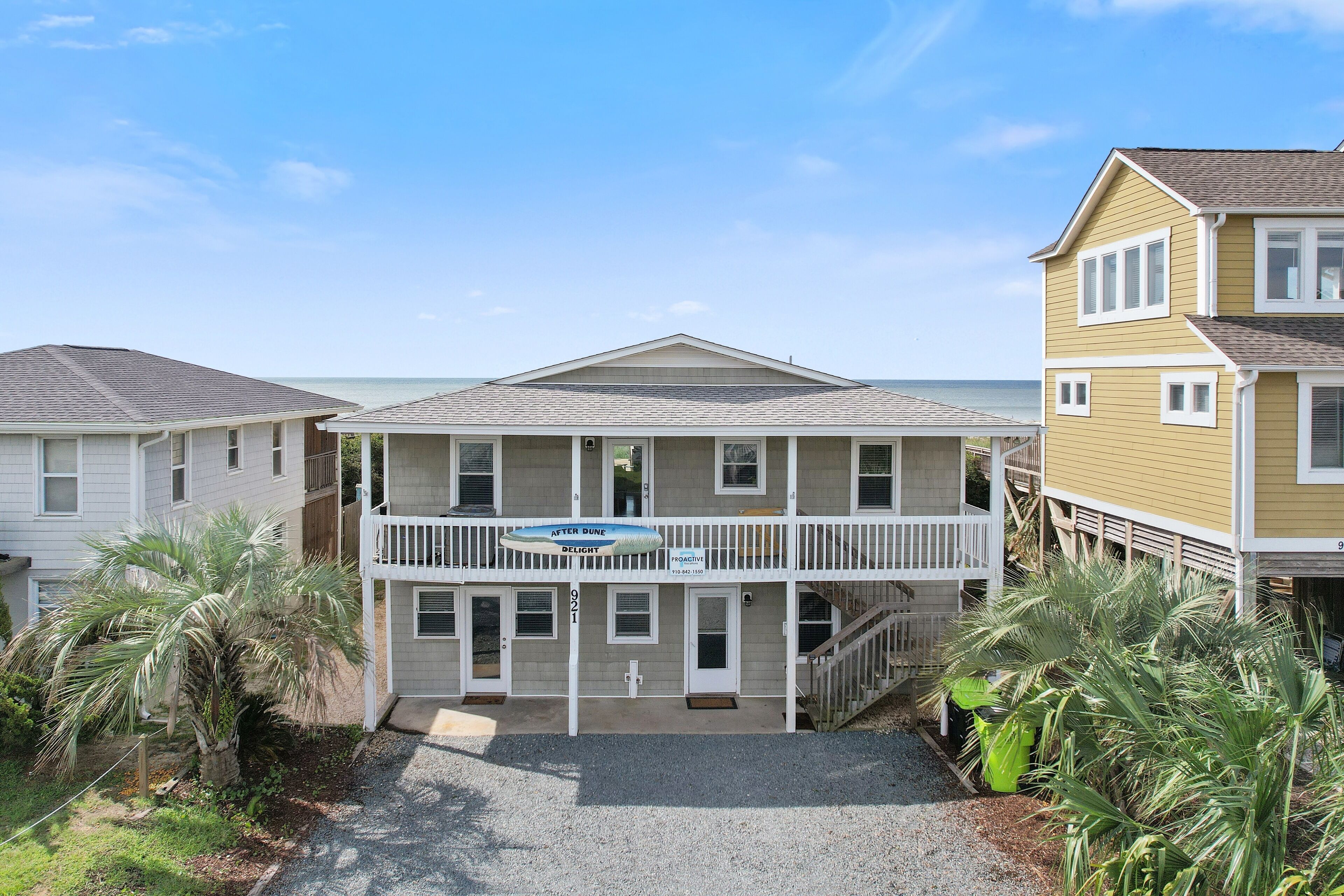A two-story building with a balcony and a sign that reads "After Dune Delight."