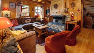 Ein gemütliches Blockhaus-Interieur mit Kamin, Holzmöbeln und rustikalem Dekor.