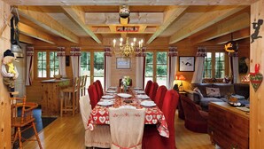 Un intérieur en bois comprenant un coin repas, un canapé et une cheminée.