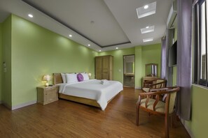 A hotel room with a bed, wooden nightstand, chair, and a desk with a mirror. - Golden Lotus Airport Hotel  (Hanoi)