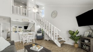 A spacious living area with a staircase, a dining area, and a kitchen.