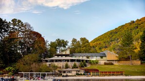 Eine am See gelegene Lodge mit Steg, überdachter Terrasse und Blick auf den umliegenden Wald.