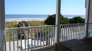 Een balkon met uitzicht op het strand en de oceaan.