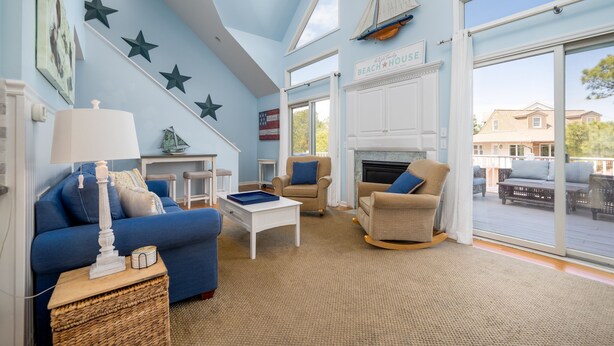 A living room with a blue sofa, beige armchairs, a white coffee table, and a fireplace. - Pet friendly home bay block in Broadkill Beach! 11 California (Milton)