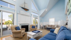 A spacious living room with a fireplace, a large window, and a view of the outdoors. - Pet friendly home bay block in Broadkill Beach! 11 California (Milton)
