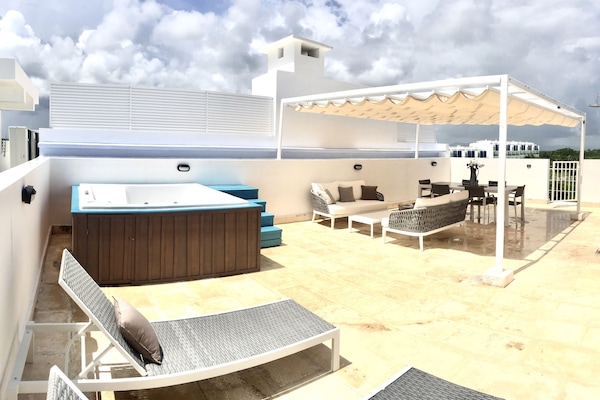Terraza Privada con mobiliario y jacuzzi privado, con vista al golf y piscina.