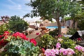 A backyard with a swimming pool, lounge chairs, and potted plants. - Pool & Garden Apartment Bakija 2, Pakoštane, Croatia (Pakoštane)