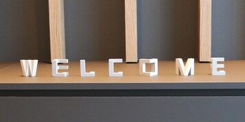 Una mesa de recepción con la palabra “BIENVENIDOS” escrita en letras blancas sobre una superficie de madera.