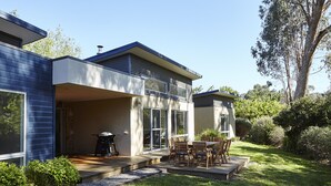Uma casa moderna com dois andares e um espaço de pátio.