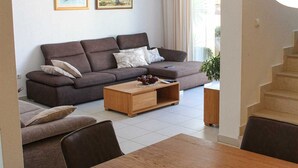 Ett modernt vardagsrum med en soffa, ett soffbord och ett matbord.
