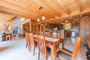 Un intérieur spacieux en bois comprenant un coin repas, une cuisine et un salon.