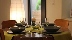 A dining table set with bowls, wine glasses, and a centerpiece with flowers. - Cottage LE PATIO (Wasselonne)