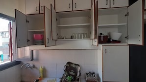 A kitchen with open cabinets, a sink, and various kitchen utensils. - Monatop  Studio Furn El Chebbek (Forn El Chebbak)