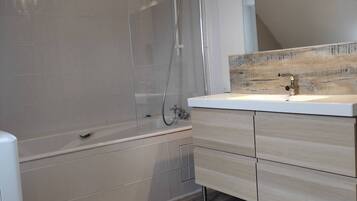 Een bad, een haardroger, handdoeken, toiletpapier