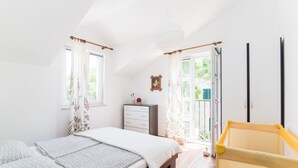 A bedroom with a bed, a nightstand, a chair, and a window. - Apartments Mare (Postira)