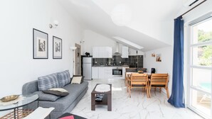A modern apartment with a living area, kitchen, and dining space. - Apartments Mare (Postira)
