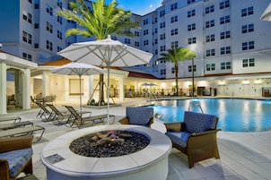 Una piscina al aire libre, sombrillas, sillones reclinables de piscina