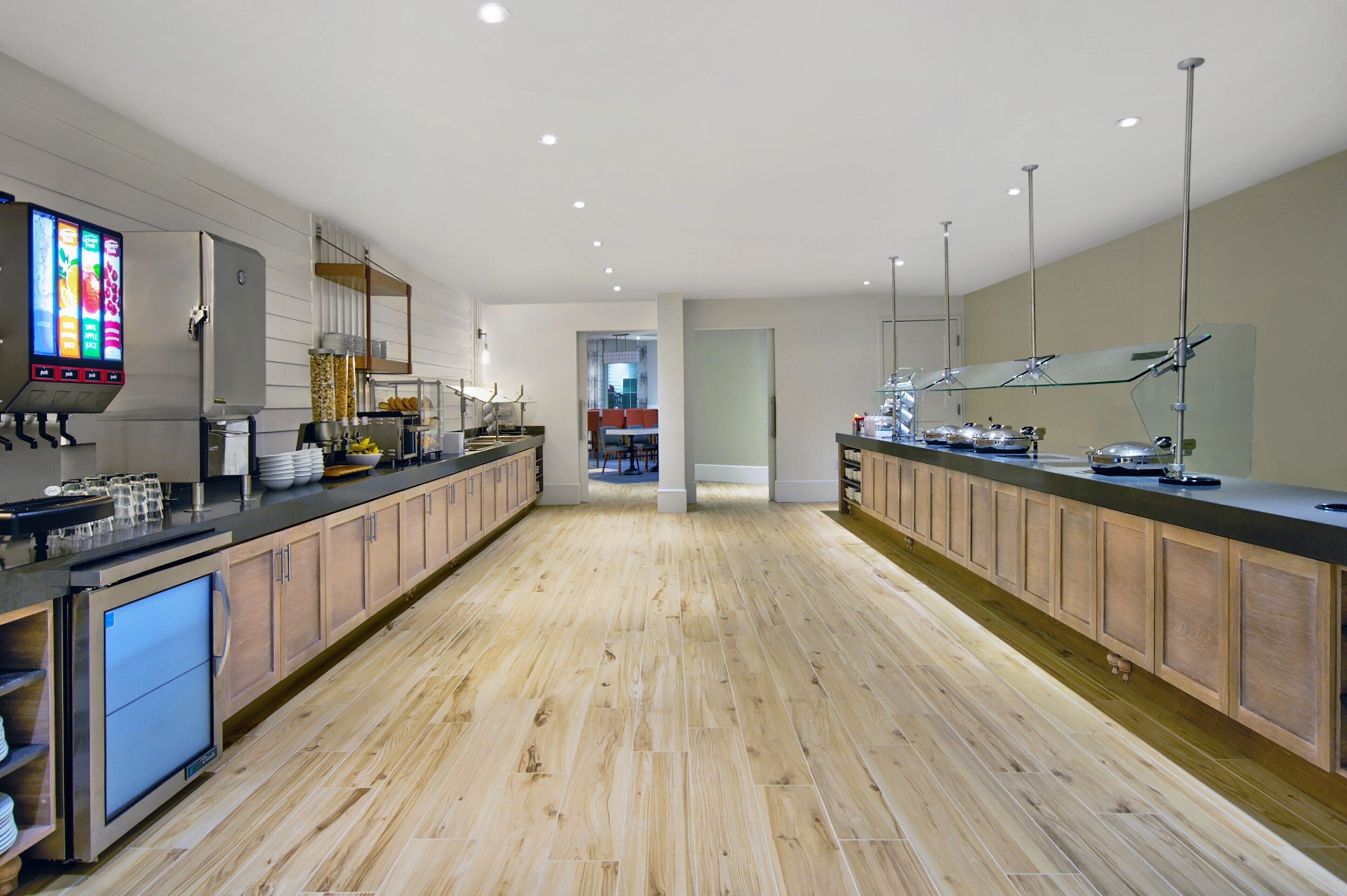 A modern kitchen with wooden cabinets, stainless steel appliances, and a digital menu display.