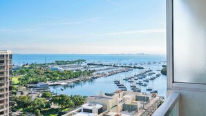 A marina with numerous boats docked, surrounded by residential buildings and greenery. - Panoramic Bay View Suite with Private Balcony (Miami)