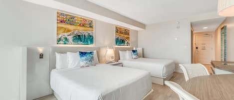 A modern hotel room with two beds, a dining table, and artwork on the walls.