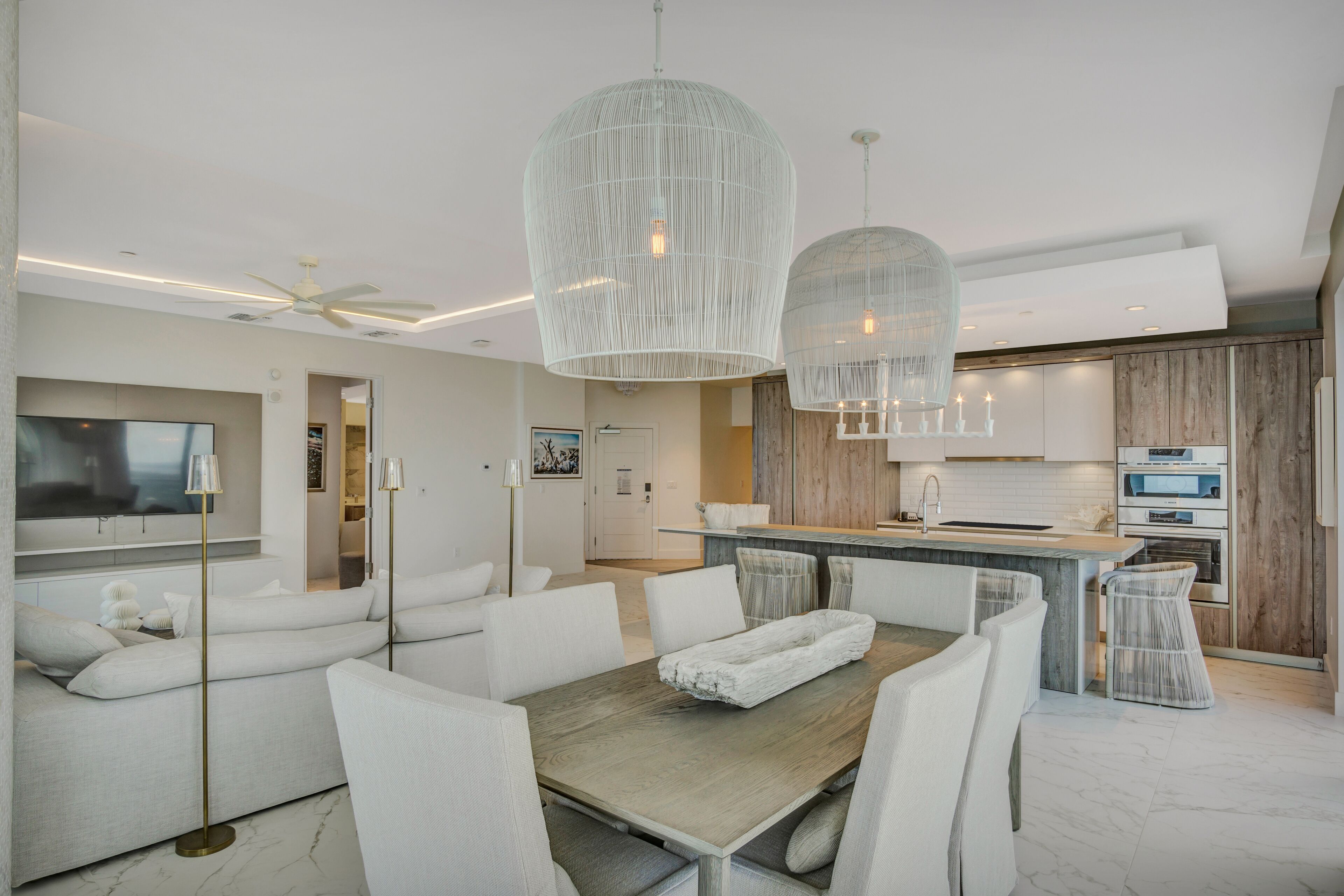 Een moderne keuken met een centraal eiland, witte kastjes en een ingebouwde oven.