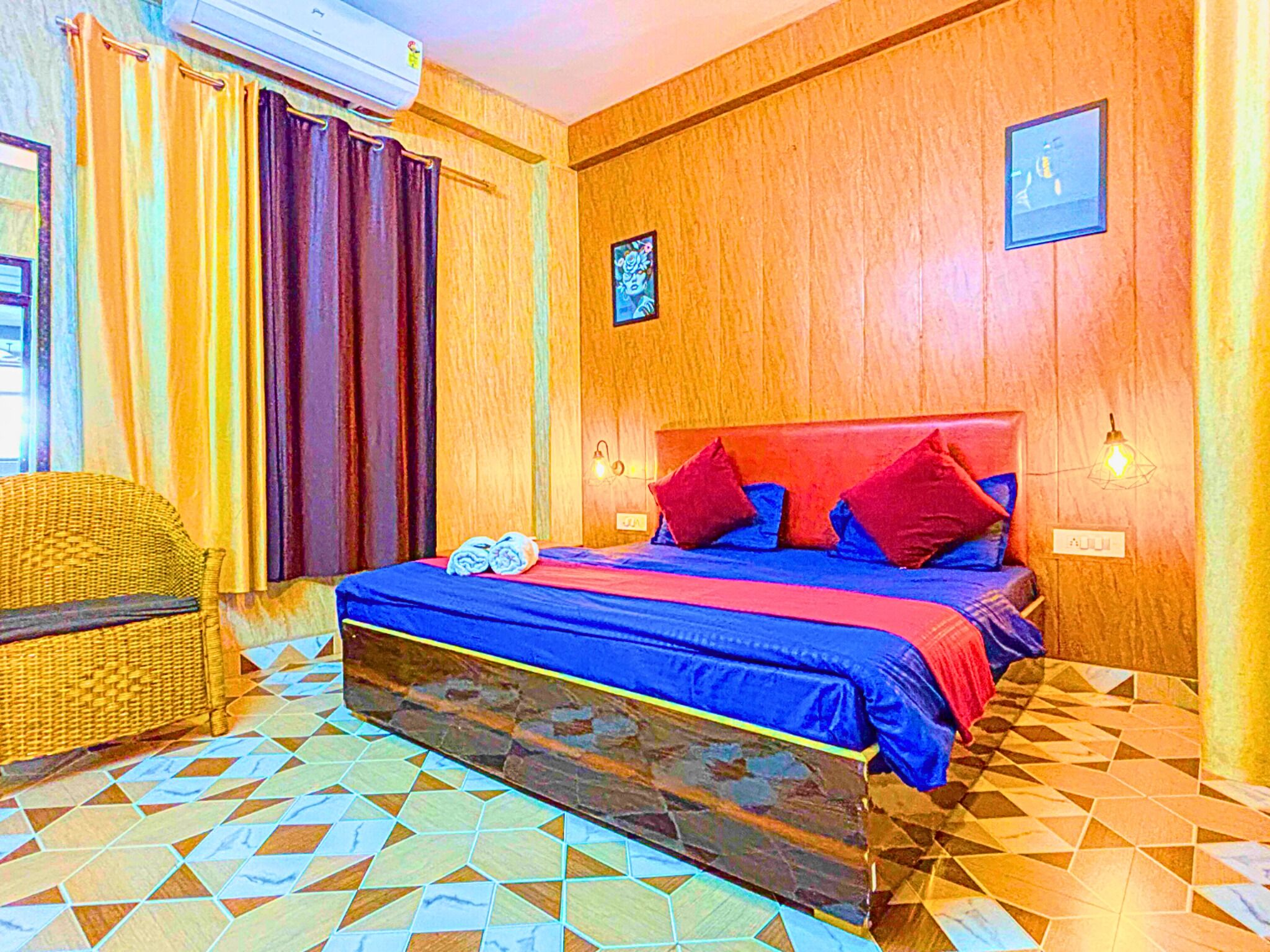 A room with a bed, a wicker chair, a tiled floor, and a wooden wall.
