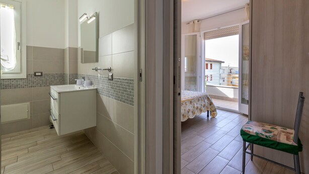 Une salle de bain avec un lavabo, un miroir et des murs carrelés.